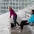 Two women in colourful clothes sitting and standing on the grandstand of the Riem riding stadium in Munich.