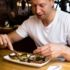 A man is eating a bavarian dish in the restaurant Schneider Bräuhaus München.