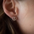 A woman is wearing an earring with pretzel motif
