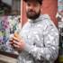 Florian Berger from Restaurant Gabelspiel in Munich in a hoodie and cap eats a Turkish sandwich