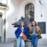 Two women stand in front of a bronze boar statue in front of the Jagd- und Fischereimuseum in Munich.