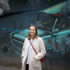 Young woman stands before a mural in Munich.