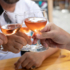 Three people toast with a glass of cool rosé.