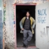 A man in work clothes stands in a painted door in Munich.