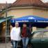 Author Daniel Speck und restaurateur Gennaro Bussone stand in front of a vintage car and smile into the camera.