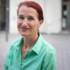 A woman with red hair smiles at the camera in Munich.