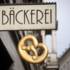 Bakery shop sign of bakery Knapp und Wenig in Munich with golden pretzel