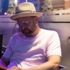 Man in pink T-shirt and straw hat studying the menu.