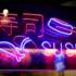 A blue and pink neon sign with the lettering Shushi.