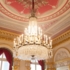 A sumptuous chandelier in front of decorated high walls in the Nationaltheater in Munich