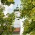 The steeple of St. George's Church in the Bogenhausen district edges between trees