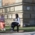 Two women are sitting on benches outside and while talking to each other.