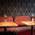 Upholstered red bench, small tables with flower vases as decoration in hotel bar Lux in Munich