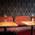 Upholstered red bench, small tables with flower vases as decoration in hotel bar Lux in Munich