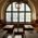 Rustic wooden tables and benches in front of a window with coloured glass blocks.