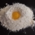 A beaten egg in a pile of flour