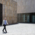 A man in a jacket walks across a square in Munich.