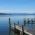 Three wooden jetties at Starnberger See in the Five Lake Region of Munich with the Alps in the background.