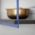 Brass bowl on black shelf.