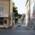 A dog runs across the cobblestones of a small side street in Munich.