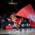 A mascot of FC Bayern Basketball in Munich rides a skateboard with a flag in his hand.