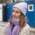 A young woman with cap and scarf in front of several containers in Munich.