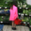 Woman in neon-coloured mackintosh standing in front of the display of a Turkish vegetable shop in Munich.