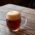 Una cerveza oscura en un vaso abombado sobre una mesa de madera