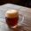 A dark beer in a bulbous glass on a wooden table.