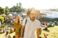 A young man and are women are climbing up a small hill at the festival Tollwood in Munich. 