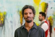 A man with a full beard is standing in front of a painting at museum Brandhorst in Munich.