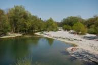 Several people lying in the sun on the Isar beach near Flaucher in Munich