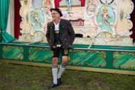 A man at the Oktoberfest who is wearing a traditional bavarian costume.