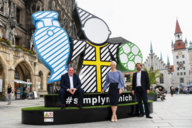Sports Officer Florian Kraus, Mayor Katrin Habenschaden and Clemens Baumgärtner, Officer for Employment and the Economy, stand in front of the Spectacular at Marienplatz.