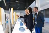 Two woman and a man are looking at exhibits at a fair trade in Munich.