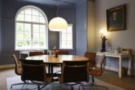 A cosy room in an old building with a round conference table and leather chairs.