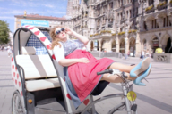 Comedian Franziska Wanninger leans on a rickshaw at Marienplatz in Munich.