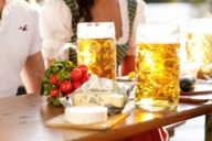 Dos Masskrüge con cerveza y un manojo de rábanos sobre una mesa en una cervecería de Munich.