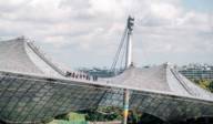 People stand on the tent roof of the Olympic Stadium in Munich during a tour.