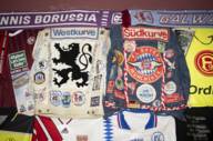 Historical football fan merchandise such as a jacket from FC Bayern Munich with various stickers and a jacket from 1860 Munich in the same style in Munich.