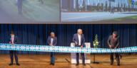 Four men stand on a stage in Munich and ceremoniously open the hotels.