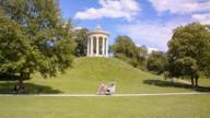 A rickshaw rides along the path below the Monopteros in the English Garden.