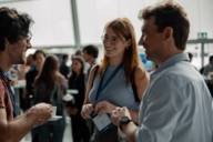 Three people stand together at Graphene Week in BMW Welt Munich.