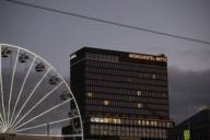 The illuminated Werksviertel Mitte building with white Ferris wheel against the evening sky