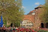 People sitting on a restaurant terrace in front of Sendlinger Tor in Munich