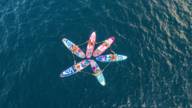 Six people do SUP yoga on Lake Starnberg.