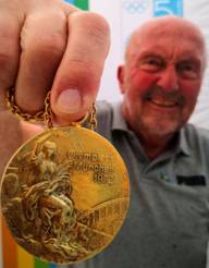 The 1972 Olympic champion in the javelin throw holds his gold medal in the camera.