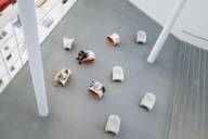 A family is sitting on stools in front of a vitrine in the Pinakothek der Moderne in Munich.