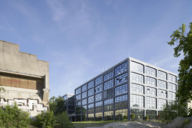 A modern building stands next to an old factory building.