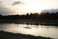 A rowing boat with five rowers in the evening light on the regatta course in Oberschleissheim near Munich.
